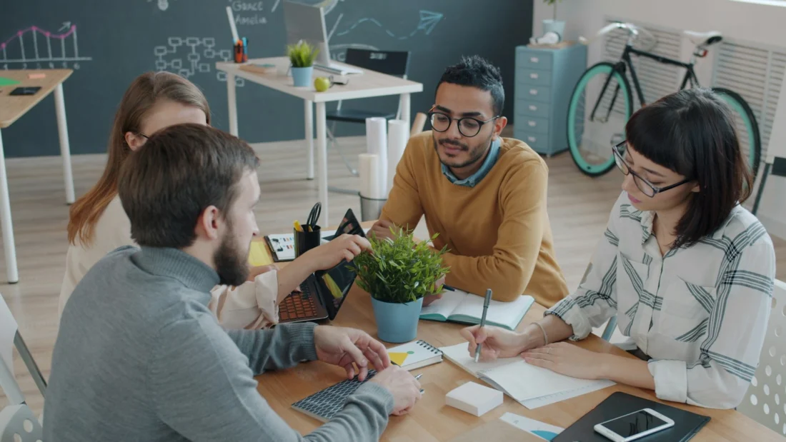 A small group working through notes together around a table
